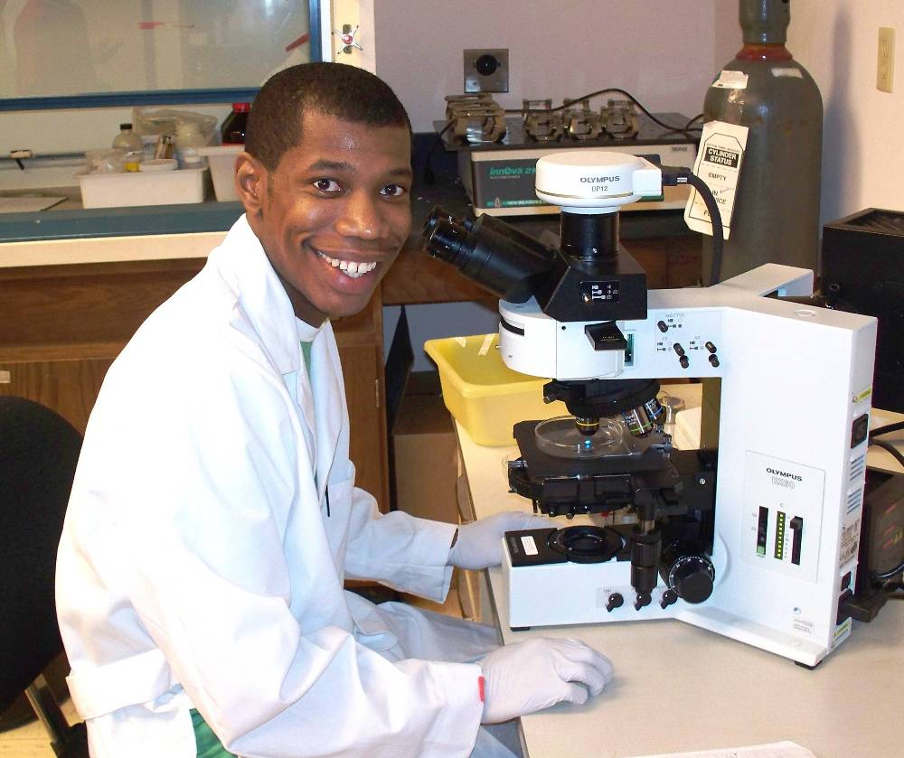 Man with a microscope in a lab coat